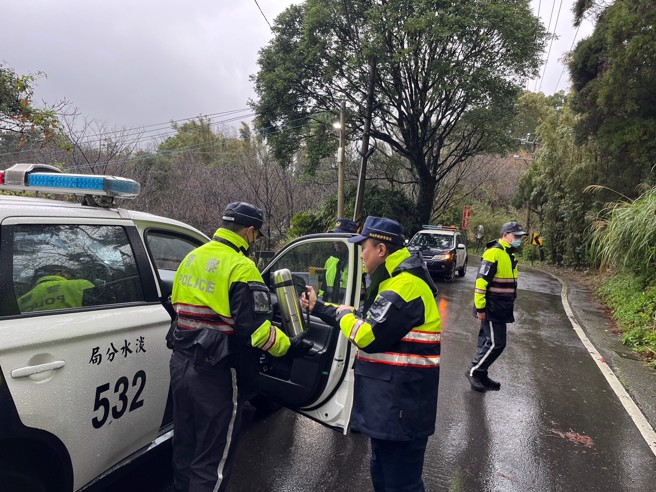 淡水分局长彭正中体恤员警吹着寒风值勤，特别在督勤时带着热姜茶给同仁去寒。(叶庭欣/翻摄)