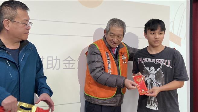 蔡衍明愛心基金會「公益青年送愛下鄉趣」23日來到宜蘭縣南澳鄉，基金會課長周哲仁（右二）送上紅包與旺旺福袋，讓鄉親過好年。（吳佩蓉攝）