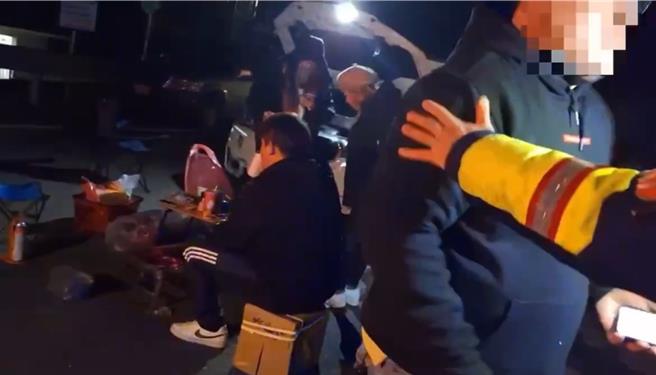 追雪民眾在翠峰管制站停车排队，22日晚间8时许大喇喇在台14甲线大马路上摆起桌椅烤肉，警方上前劝导。（警方提供／杨静茹南投传真）