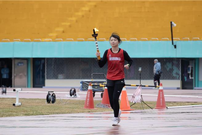 国女3000公尺健将余棱娴高举圣火进场。（苗栗县政府提供／李京升苗栗传真）