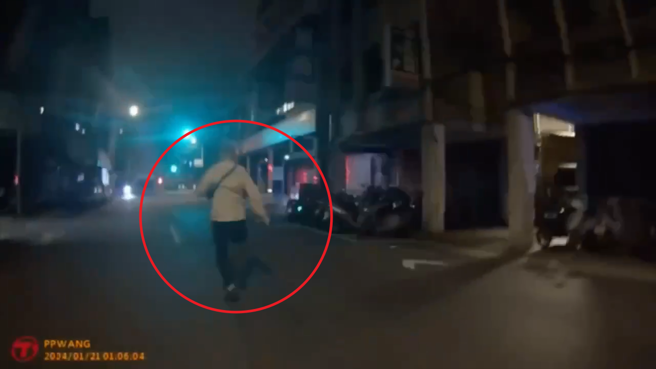 王男暗夜違規過馬路，見警立即拔腿狂奔，實習警順利活逮通緝犯。（翻攝畫面）