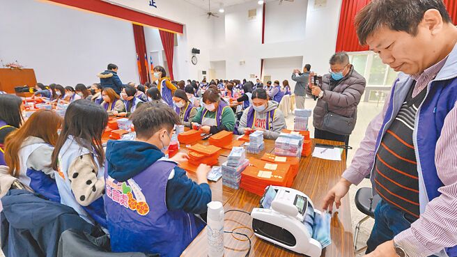 澎湖縣23日起普發長者5000元春節禮金，澎縣府社會處人員借用選委會2樓禮堂，在警方派員戒護下進行點鈔裝紅包袋作業。（許逸民攝）