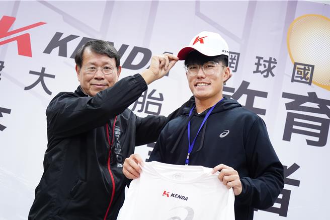 杨启仁（左）亲自将印有建大logo的新球帽戴到许育修（右）的头上。（吴建辉摄）