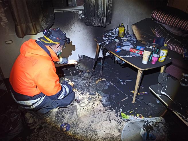 基隆市福一街一处民宅屋主傍晚发现放在客厅的一台除湿机突传爆炸声响，接着冒出火烟，消防人员获报后赶至现场，初步调查除湿机疑自燃后整个烧毁，图为消防人员于火场鑑识。（基隆市消防局提供／徐佑升基隆传真）