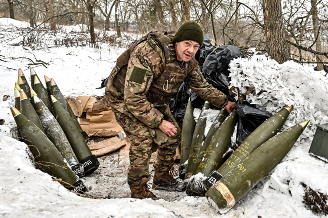 2024年1月14日，一名乌克兰军人在前线附近准备155毫米炮弹。（路透社）