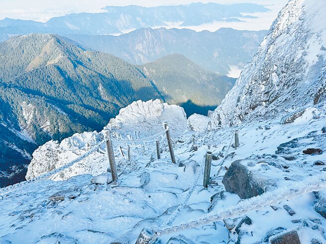 玉山24日天氣放晴視察雪況，玉山主峰步道積雪約10公分，碎石坡至主峰頂步道結硬冰，即使穿戴冰爪行走仍步步驚心，回頭俯瞰山腳下是雲海美景。（玉山國家公園提供／楊靜茹南投傳真）