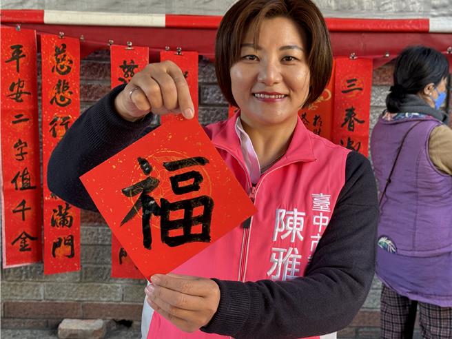 台中市国光里福正宫26日举办「写春联、送春联」活动，市议员陈雅惠也小试身手写下「福」字，提前向民眾拜早年。（王煌忠摄）