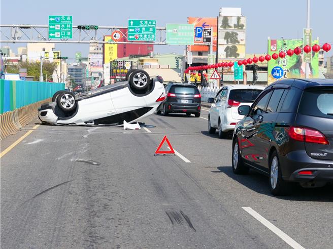 雲林縣北港鎮北港大橋27日上午10點許發生翻車意外，1輛自小客車為閃避前方突然切入車道的車輛，撞上分隔島翻覆4輪朝天，吳姓女駕駛自行脫困，幸無生命危險。（張朝欣攝）