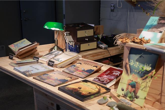 基隆塔內的「崆書屋」內部環境與陳列書籍，策展人王騰崇說，店內書櫃是使用柳安木，是從舊船廠蒐集船上的「跳板」打造而成，書屋中的銘牌是使用耐厚鋼製成，材料都與基隆在地息息相關。（基隆市政府提供／徐佑昇基隆傳真）