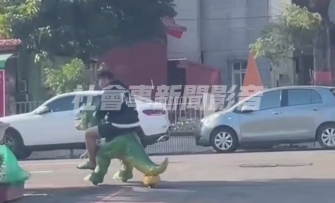 男子骑着绿色的恐龙车，在高雄的鸟松区大昌路上逛大街。（翻摄社会事新闻影音）