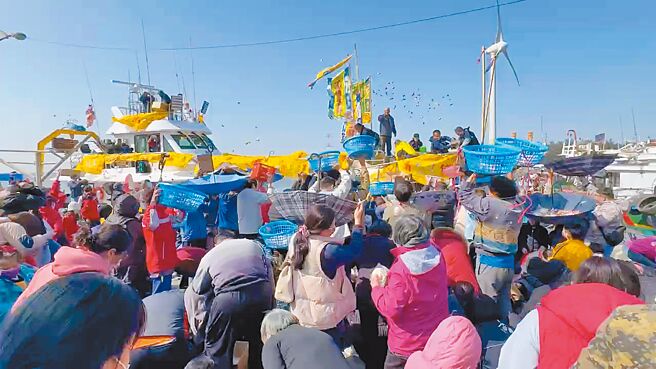 彰化縣線西鄉漁民黃超群訂造多時的的新船26日從宜蘭南方澳駛回線西塭仔漁港，新船進港時向岸邊聚集的群眾撒下總計1公噸的麻糬、包子、糖果及餅乾，場面熱烈。（孫英哲攝）