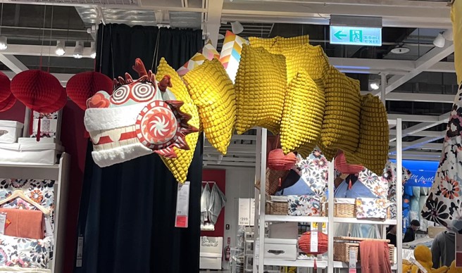 IKEA店員用賣場現有的商品，包括龍頭造型抱枕及一排黃色抱枕，排成一條龍。（圖／網友授權提供）