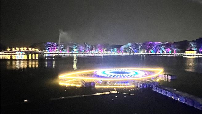 台南首届「新营波光节」28日启灯开幕，以湖中宽达15公尺的《光之眼》作品，融合天鹅光雕投影璀璨揭开序幕，吸引许多民眾亲临现场感受。（张毓翎摄）