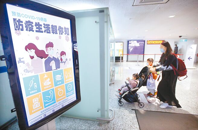 國內新冠與流感疫情持續升溫，預估兩種疫情都在春節期間達到高峰。圖為桃園機場入境管制區內，剛下機的旅客正走過發燒篩檢站。（范揚光攝）