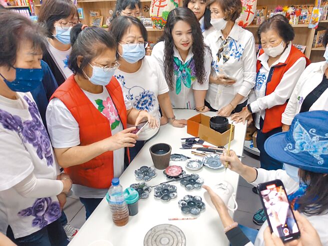 參與青花瓷繪製課程的學員，圍著老師聽講學習。（柯毓庭攝）