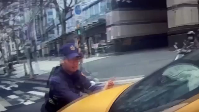 内科上班尖峰时间，计程车突然抛锚，员警立即救援帮助推车。（翻摄画面）