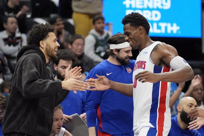 杜伦(右)兴奋跟场边穿便服没打的康寧汉击掌庆祝。(美联社)