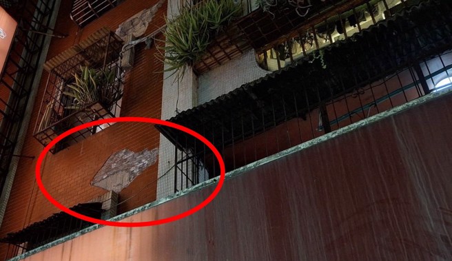 新北市汐止區明峰街晚間有公寓外牆磁磚剝落，所幸沒有砸傷人。（翻攝畫面）