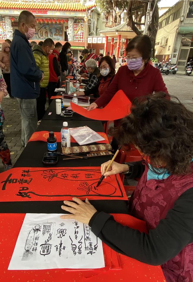 台中市樂成宮30日舉辦「春節揮毫贈春聯」活動，鄉親排隊索取春聯。（陳淑芬攝）
