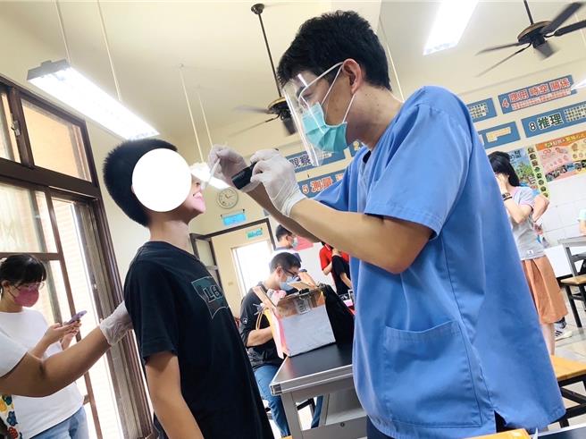 牙科诊所医师卢冠宇(右)建议，定期涂氟、吃氟锭，再搭配正确的日常口腔保健，便能有效预防及控制儿童蛀牙问题。(图／卢冠宇牙科诊所提供)