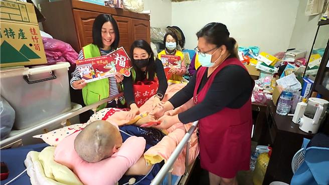 女星林利霏（左）響應創世基金會第34屆寒士吃飽30活動，與創世台東院到宅團隊到宅關懷植物人。（蕭嘉蕙攝）