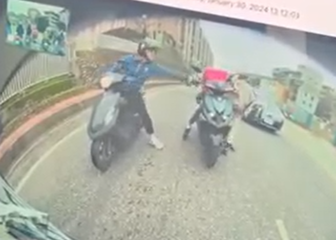 有外送员停等红灯时弯腰捡东西，不料，却被一旁骑士「扶机车」时，疑似催到油门，导致连人带车爆衝撞特斯拉。（图／翻摄自脸书爆废1公社）