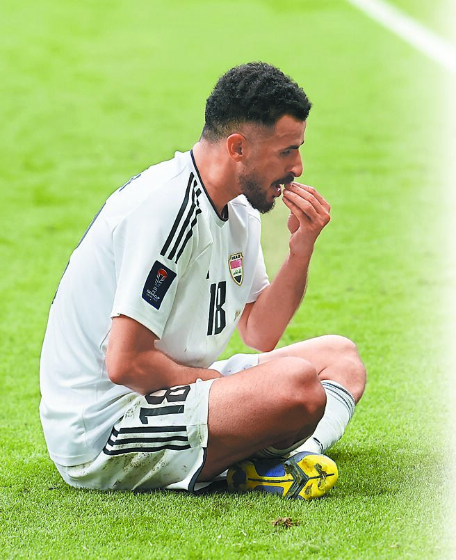 伊拉克前锋艾门胡辛进球后坐在地上做出抓取食物的庆祝动作，却被第2张黄牌罚下。（路透）