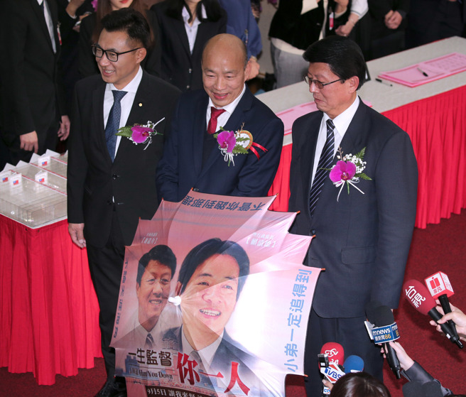 立法院第11届立委1日报到就职，国民党立委谢龙介（右）带着道具伞来报到，并在联访时开伞，和国民党立委韩国瑜（中）、江启臣（左）一同受访。（黄世麒摄）