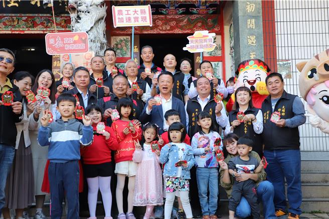 嘉義縣長翁章梁到大埔鄉北極殿發龍年紅包，大人小孩都開心搶先拿到。（廖素慧攝）