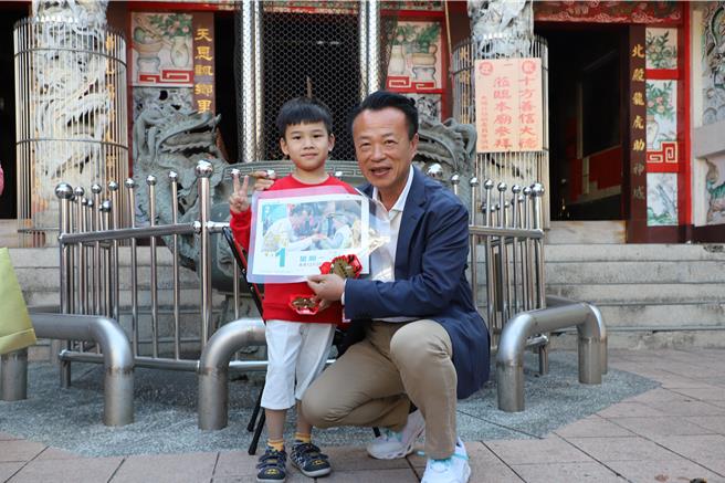 嘉義縣長翁章梁到大埔鄉發龍年紅包給這名男孩，並為他簽名合照。（廖素慧攝）