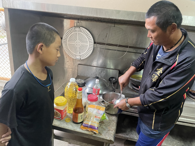 金潭国小棒球队总教练徐宏根（右）化身大厨，为小球员们准备晚餐。（顶新和德文教基金会提供）