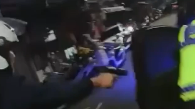 员警朝汽车轮胎开2枪。（图 / 刘咏韵翻摄）