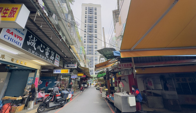 新店惠国市场与紧邻五峰重划区，巷内传统市场景象与一路之隔的新建大楼成强烈对比。（图／吕健豪摄）