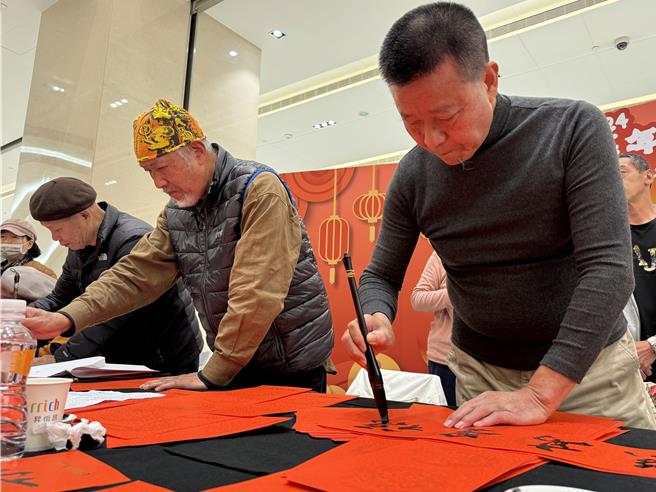 前金门县长李炷烽(右)人气爆棚，不少民眾都排队请他写下心中喜爱的吉祥话春联带回家张贴。(于家麒摄)