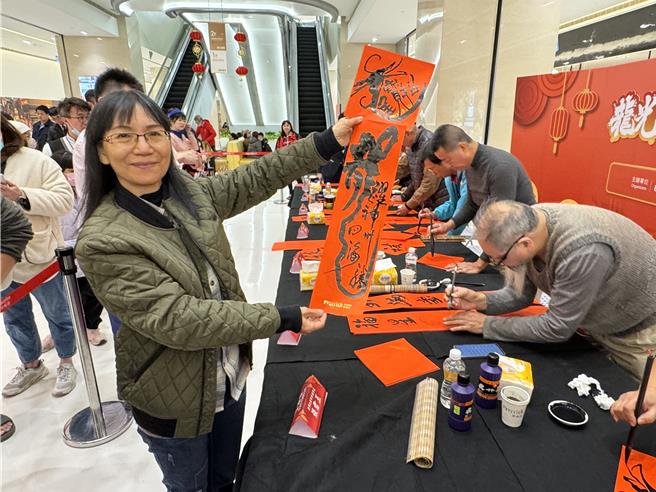 不少民眾慕名排队索取春联，现场还可请仰慕的书法大师帮忙写下自己喜爱的吉祥话，为新年增添好彩头。(于家麒摄)