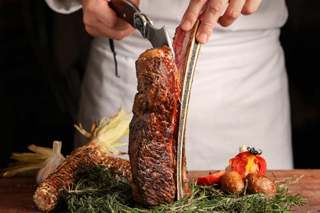 台北晶華酒店獨家推出總長30公分、份量達36盎司的「加長型美國帶骨牛小排」，可同時品嘗焦香骨邊肉及軟嫩肉質。（台北晶華酒店提供）