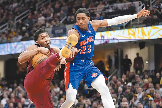 面對活塞後衛艾維（右）的拚搶，騎士後衛米契爾死命護球的動作像是在踢足球。（美聯社）