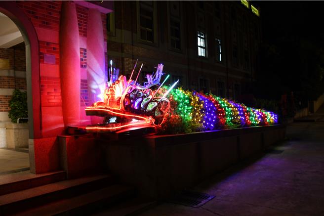 金门县消防局春节布置发挥巧思，将报废的水带做成龙首，花台树丛为龙身，搭配夜间绚丽的灯光，化身为2条瑞气千条的七彩祥龙。(图／金门县消防局提供)