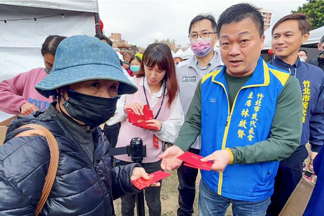 竹北乐龙龙年货大街3日开幕，竹北市代会主席林启贤在现场发放竹北龙天护佑限定福袋。（罗浚滨摄）