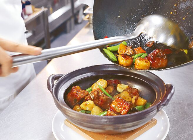 4.備砂鍋，若干九層塔鋪在砂鍋底部，使香氣更均勻；其餘的則下鍋快炒，讓食材保有九層塔的獨特香氣。鍋內食材拌炒後即可裝入砂鍋內。（陳俊吉攝）