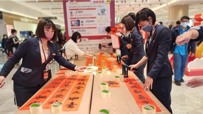 2024年2月4日澎湖县／澎坊免税店迎春挥毫，预告春节5天活动，4日下午在三号港一楼大厅举办【2024龙年迎春挥毫趣】活动，邀请书法名家为当地旅客及居民写春联、画字画，并找来员工跑腿帮以吹风机吹乾。（许逸民摄）