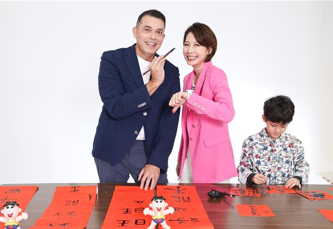 丁寧小儿子（右）无视爸妈（左）在旁拍照，完全投入在写春联的世界，相当可爱。（陈俊吉摄）