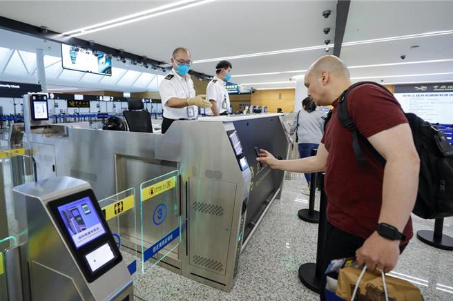 大陸官方報告顯示，2023年外國人出入境人次只恢復至疫前36％。圖為成都天府國際機場，海關關員指導一名外國旅客通關。（圖／新華社）