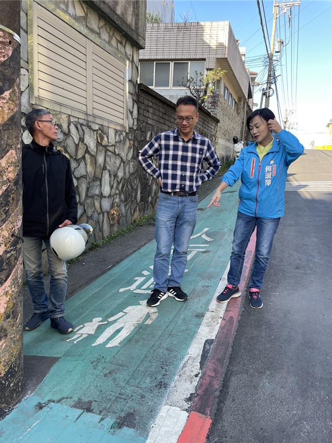 因为施工单位的便宜行事，基隆市信义区教孝街单号侧的绿底人行道，每到雨天就滑溜不堪，并曾造成多人滑倒。市议员何淑萍（右1）与市府工务处协调，刨除绿底部分，仅留人行道标注。（何淑萍服务处提供／张志康基隆传真）