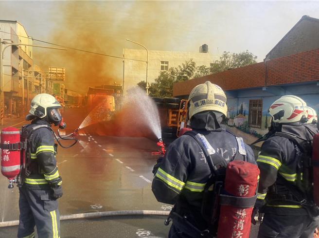 彰化县伸港乡中兴路二段6日下午发生货柜车翻覆事故，肇事货柜车载运因车危险物品硝酸，翻车后外泄橘色气体，消防员全戴上呼吸面罩，以水注灌救。（民眾提供／孙英哲彰化传真）