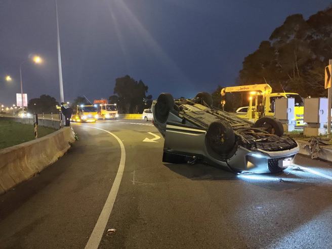 女子开车下匝道时，自撞分隔岛翻车。（翻摄画面）