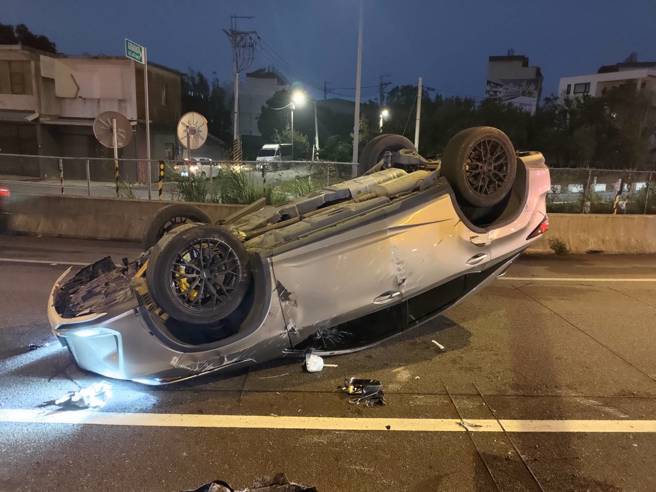 女子开车下匝道时，自撞分隔岛翻车。（翻摄画面）