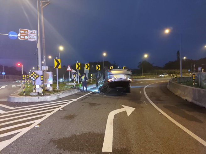 女子开车下匝道时，自撞分隔岛翻车。（翻摄画面）