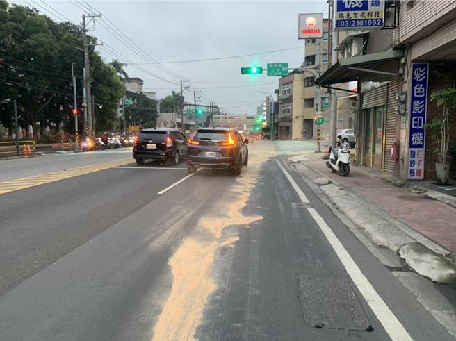 桃园警分局埔子派出所巡佐黄国梁及警员张品莉6日接获民眾报案，永安路往市区方向的道路上有长约80公尺的油渍，恐有造成机车骑士滑倒的危险，员警拿木屑吸油。（警方提供）