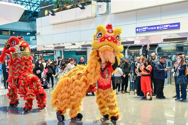 恒昌免税店7日在桃园国际机场第二航厦中央区出境大厅，安排舞狮绕场表演展示吉祥话，以及财神爷发放糖果，与出国旅客同欢，不少旅客抢着与财神爷拍照，搭配着「新年快乐」、「财源滚滚」手举牌，让游客在春节前夕就能感受浓厚年味。（陈麒全摄）